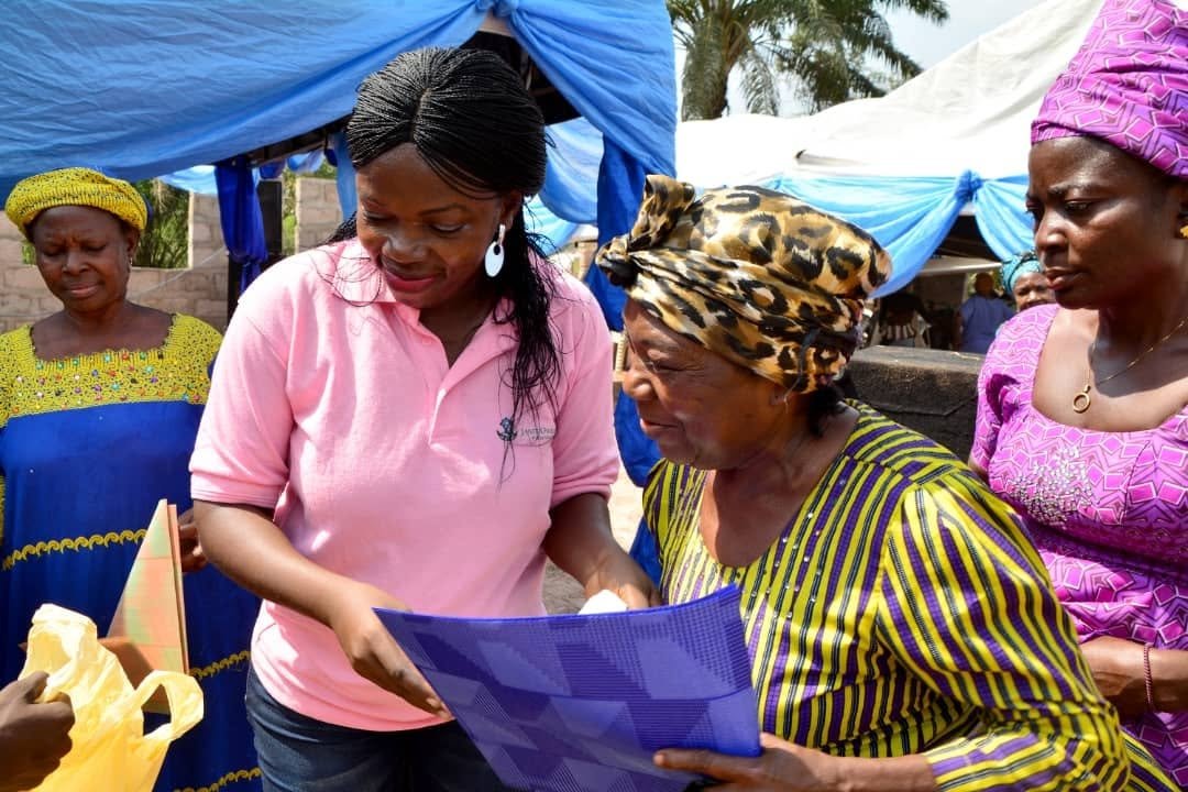 JOF volunteer handing a welfare package to a beneficiary